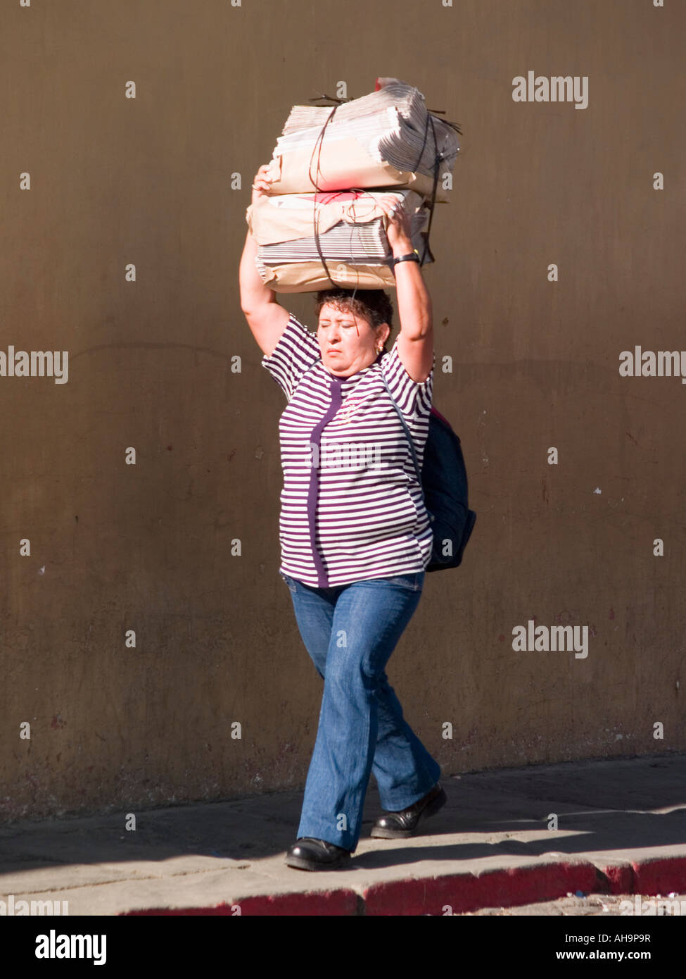 Mujer que llevaba un paquete en la mañana en las calles Foto de stock