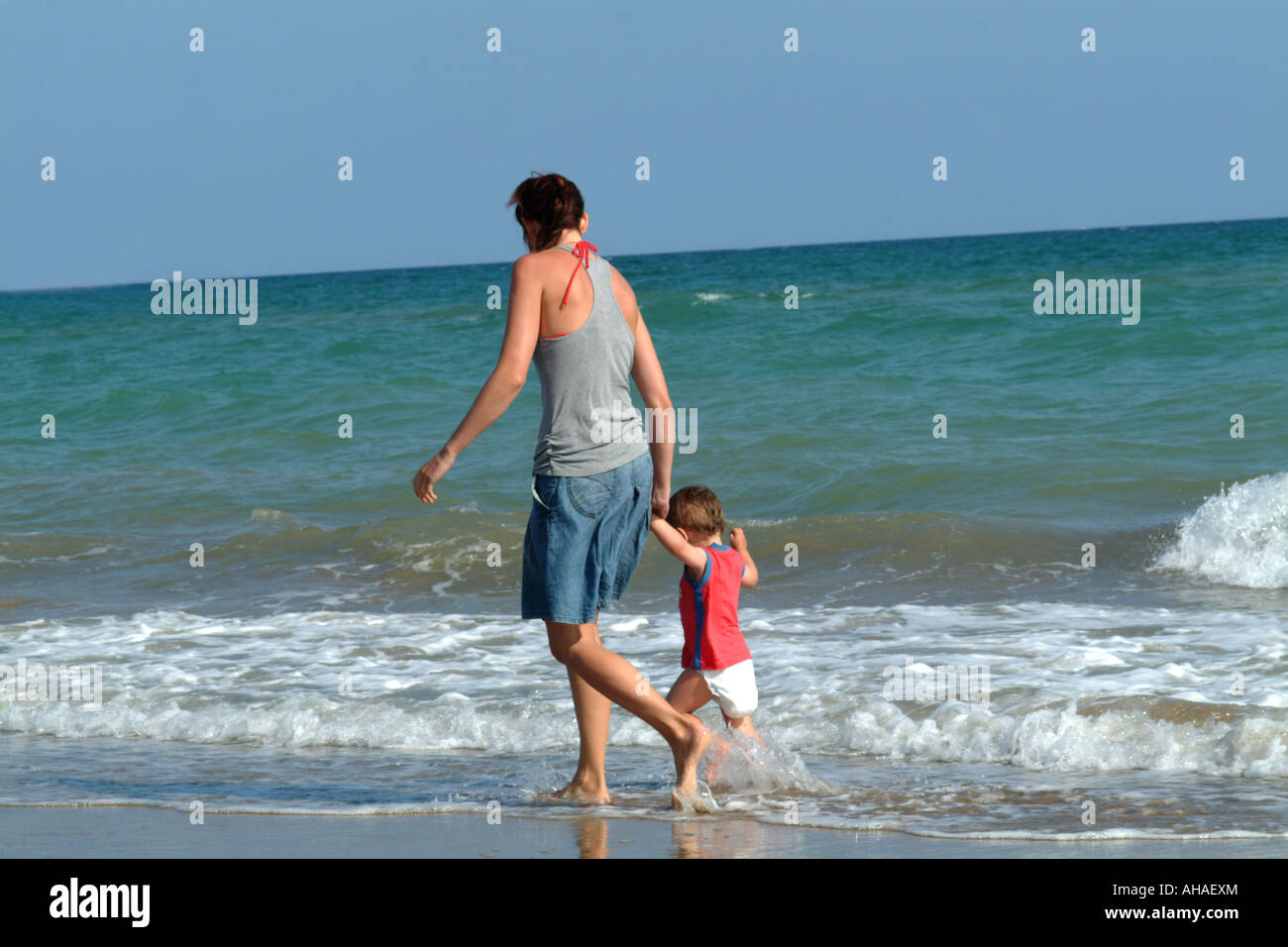 Una madre y su hijo para caminar en la playa Foto de stock