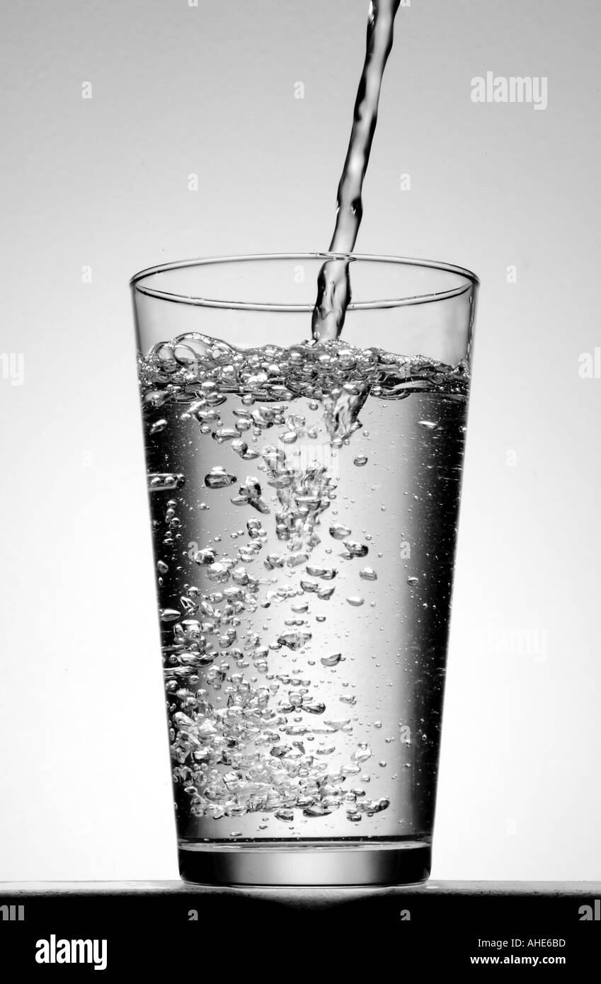 Vierte agua en un vaso Imágenes de stock en blanco y negro - Alamy