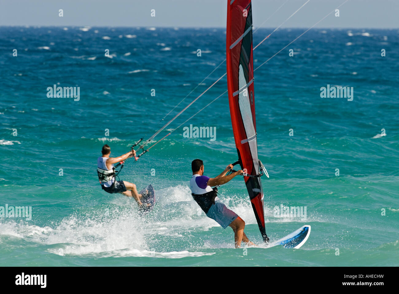 Tablas de windsurf y kitesurfer montar las olas en el mar mediterráneo. Foto de stock