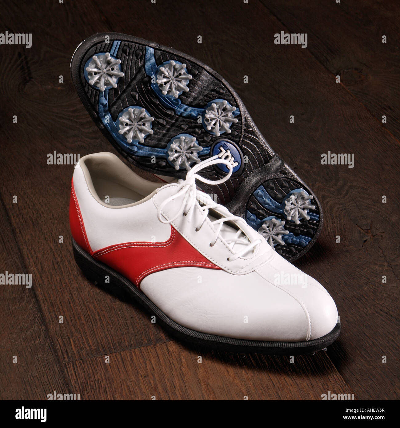 Zapatos de golf moderno sobre un piso de madera blanca y roja de cuero con  suela de plástico y picos Fotografía de stock - Alamy