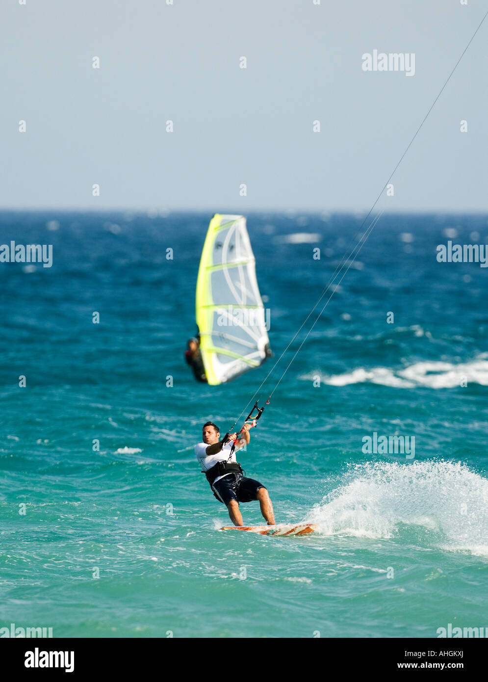 Tablas de windsurf y kitesurfer montar las olas en el mar mediterráneo. Foto de stock