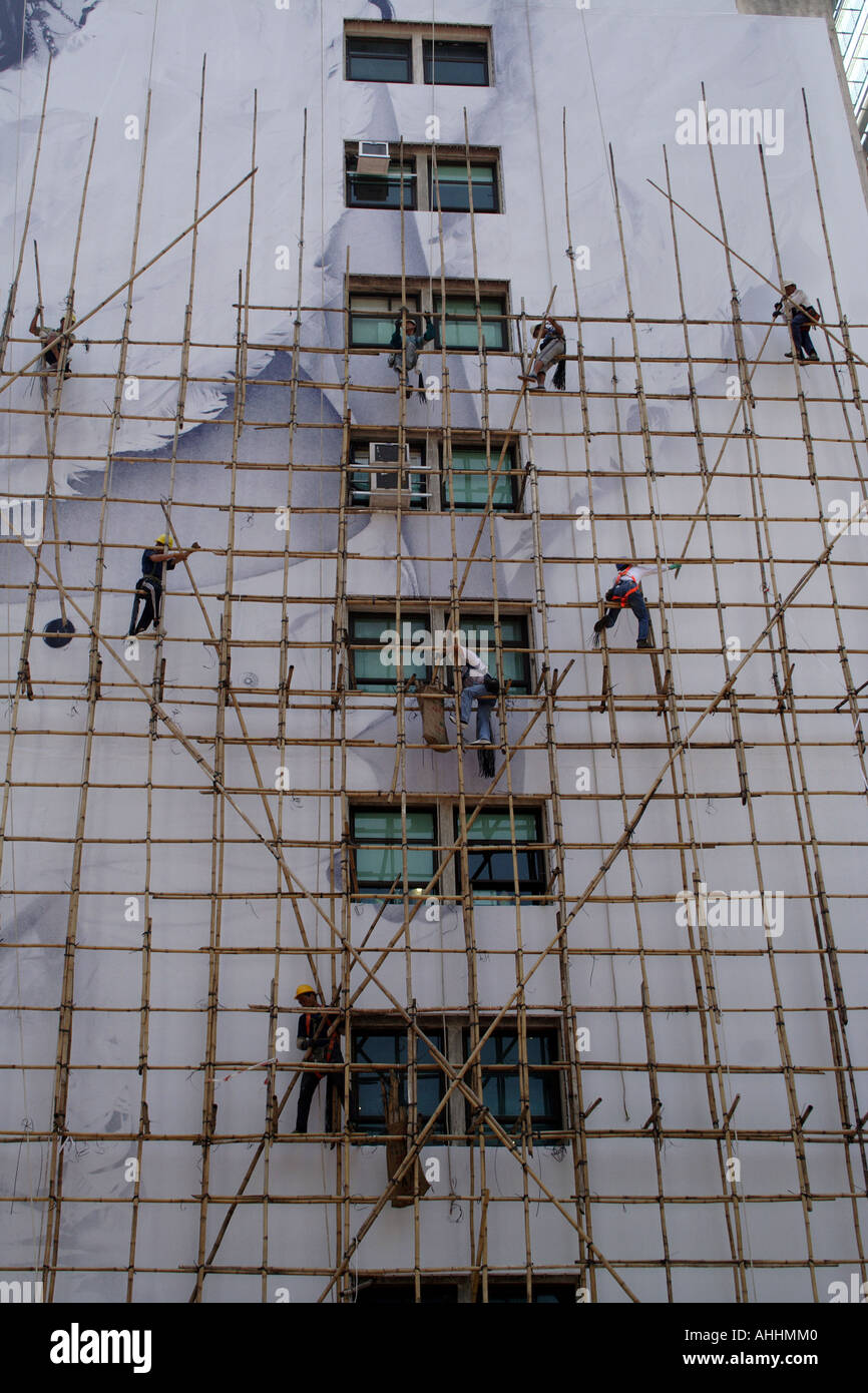 Los obreros en andamios de bambú en el lateral de un edificio, Hong
