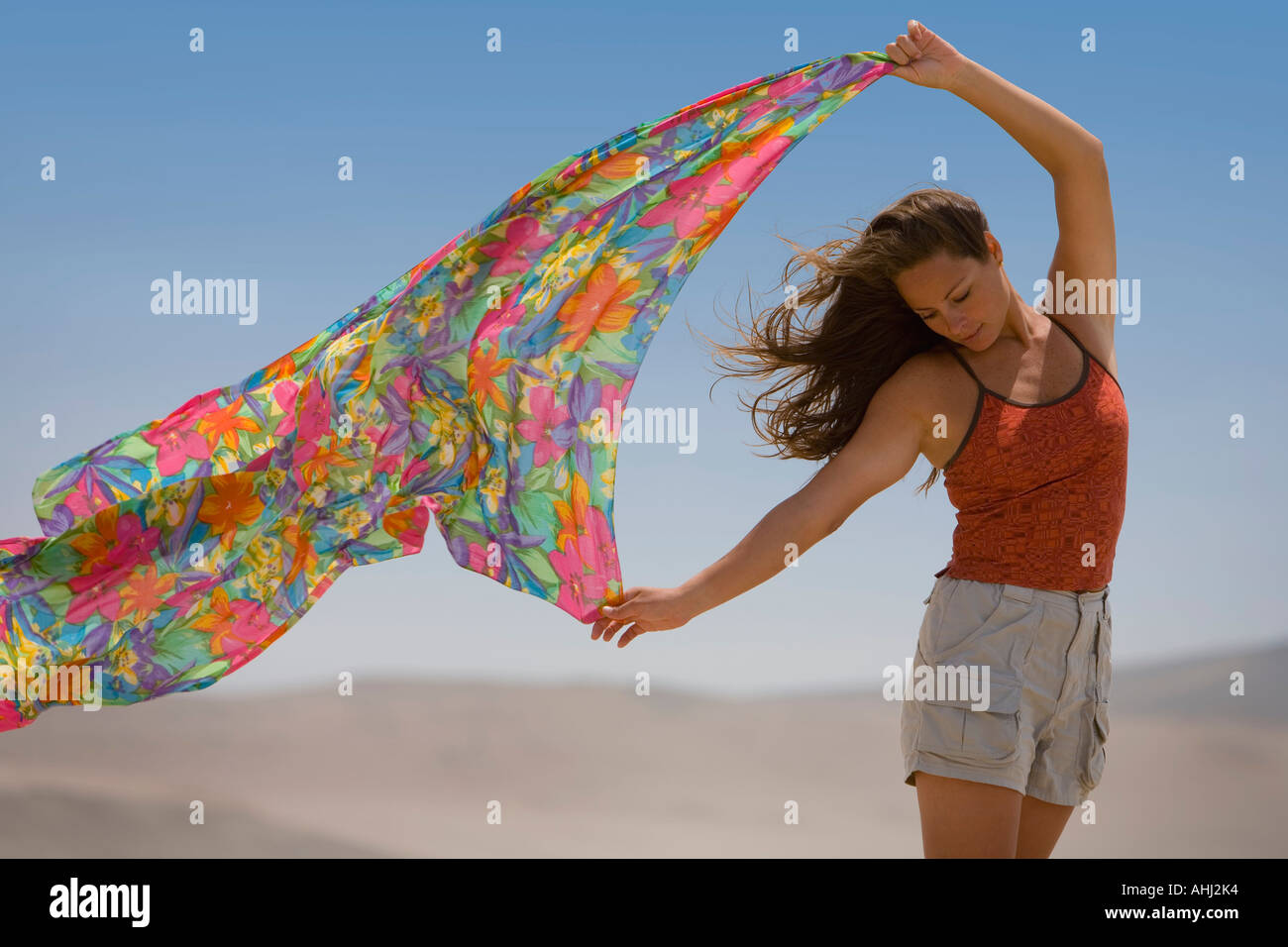 Una mujer sostiene un pañuelo en el viento Foto de stock