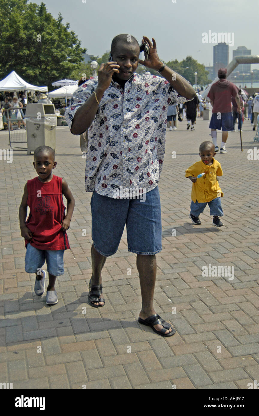 P24 041 afroamericanas Music Fest, padre de dos niños conversaciones en dos 'Cell 'Teléfonos, Hart Plaza, Detro Foto de stock