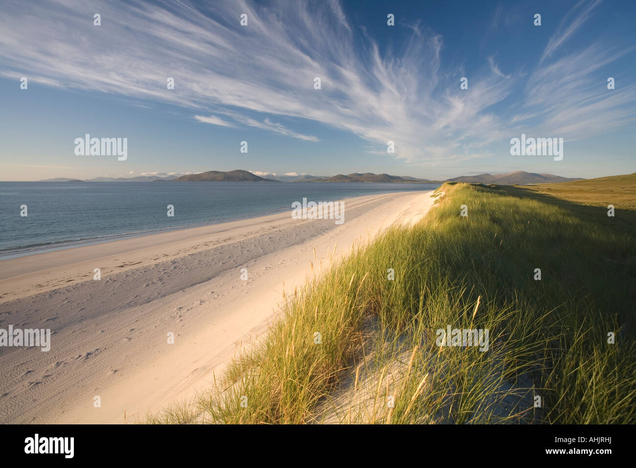 Luz roja dunas en el atardecer en la costa oeste de berneray montañosa con Harris detrás, Western Isles, Hébridas Exteriores. Foto de stock