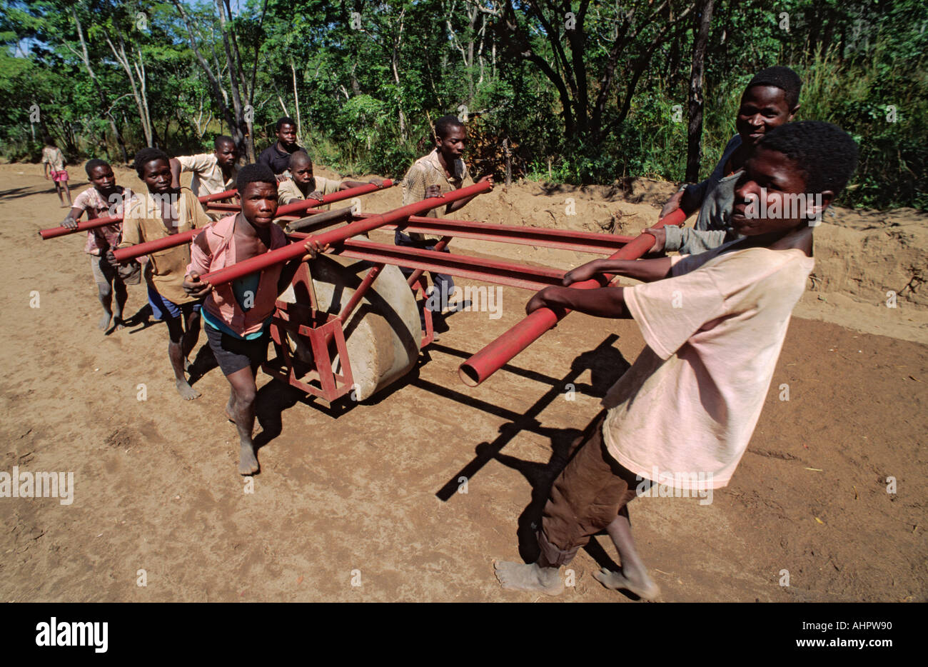 Miembros de la comunidad reconstruyendo manualmente una carretera dañada durante la guerra civil. Zambezia, Mozambique Foto de stock