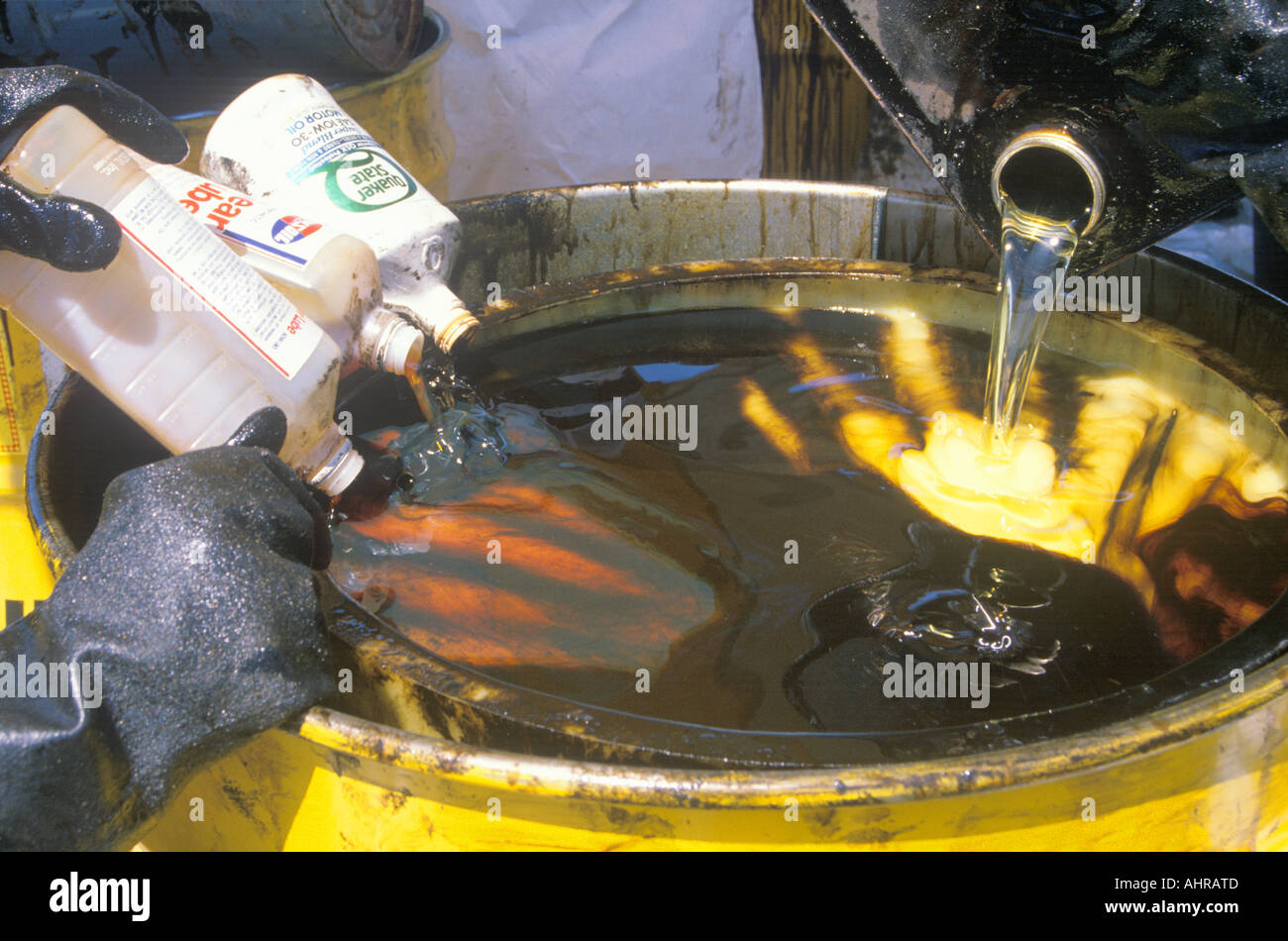 Los trabajadores vertiendo desechos tóxicos en un bidón metálico en el sitio de limpieza de residuos en el día de la Tierra en la planta de Unocal en Wilmington Los Angeles Foto de stock