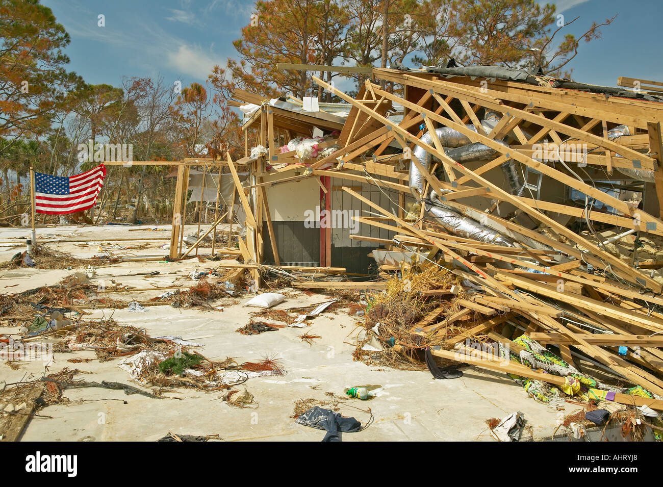 Las ondas de la bandera americana en el viento con suciedad en la parte frontal de la casa fuertemente golpeada por el huracán Iván en Pensacola, Florida Foto de stock