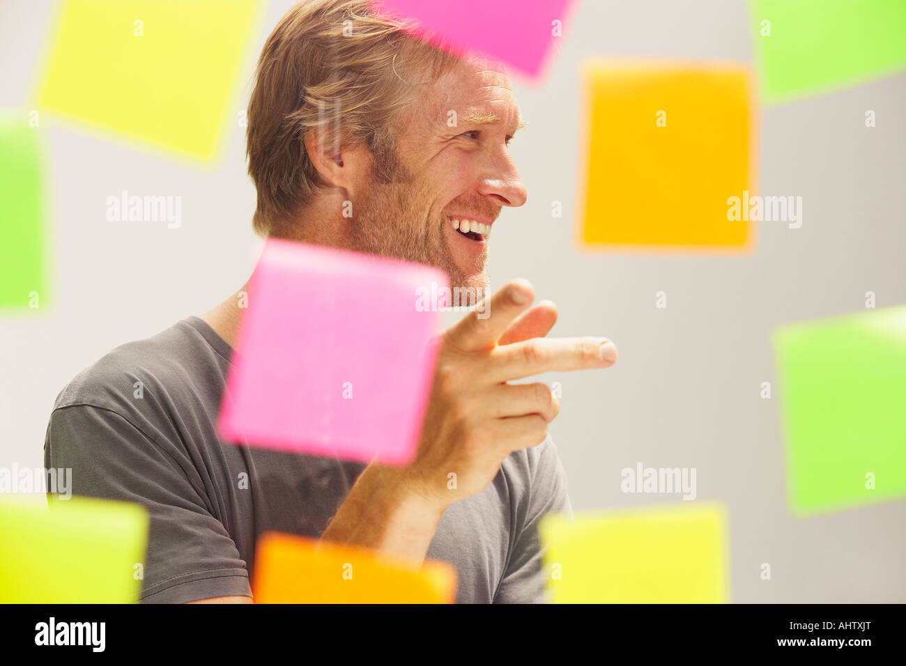 El hombre visto a través de la ventana con color notas PostIt. Foto de stock