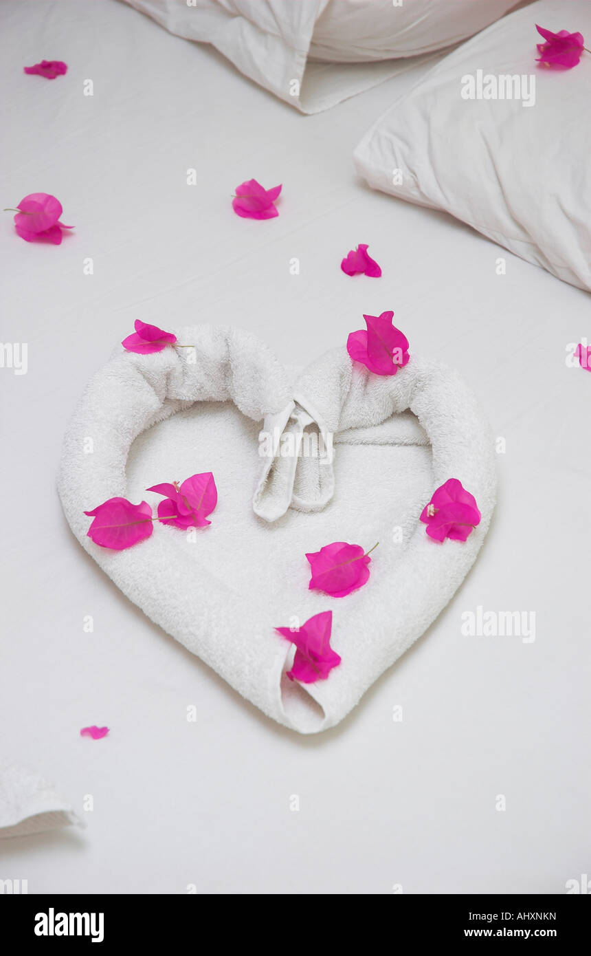 Toalla en forma de corazón en la cama en la habitación del hotel Fotografía  de stock - Alamy