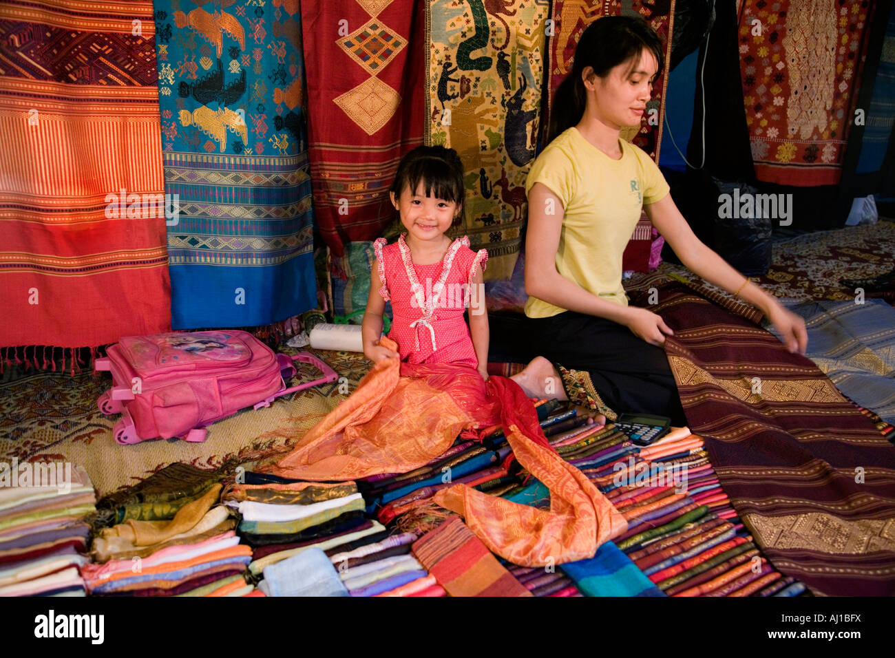 Y su hija con productos textiles en el mercado nocturno de Luang Prabang Laos Foto de stock