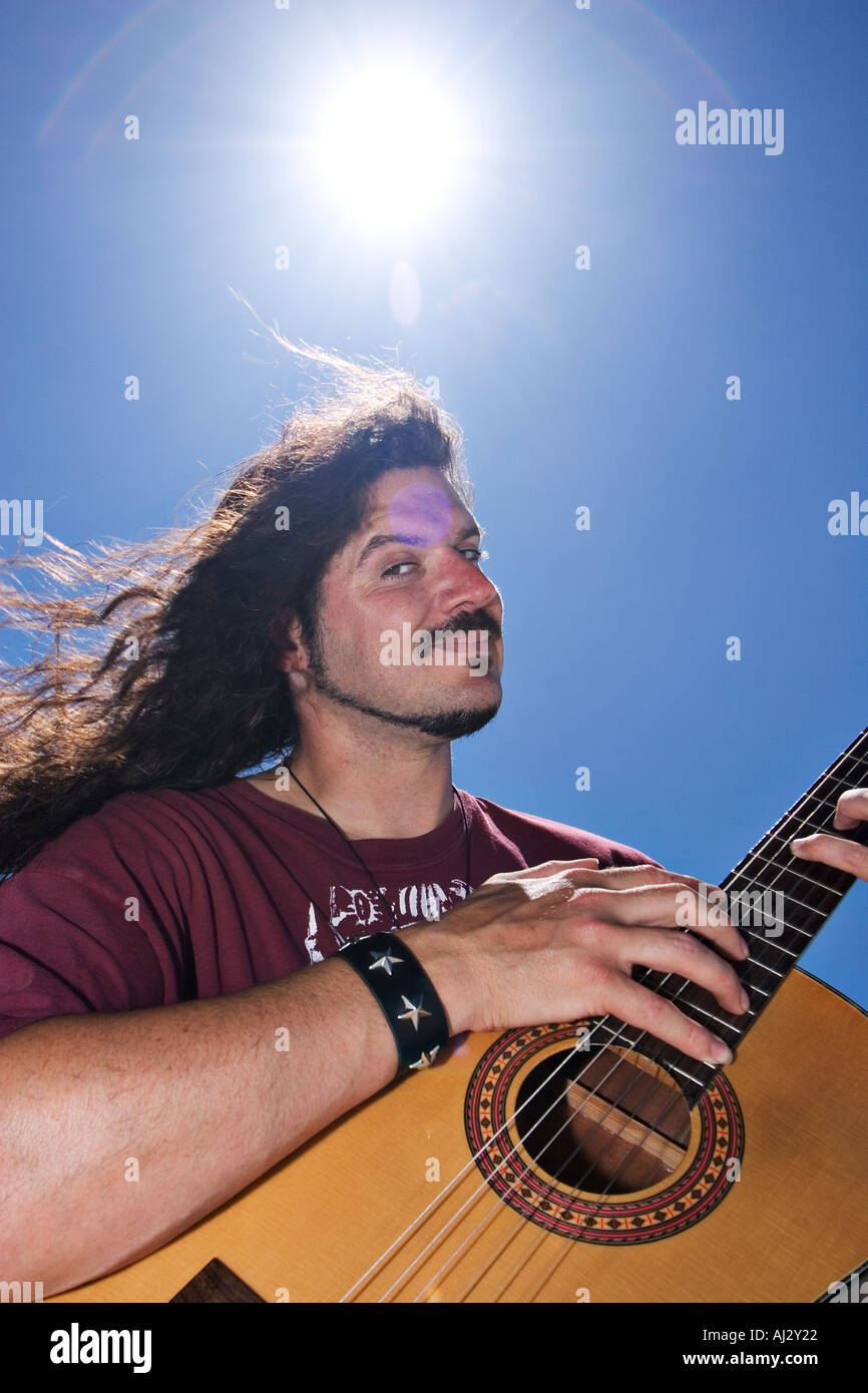 Mes Desear Nominal Hippie tocando la guitarra en el desierto con el sol por encima de su  cabeza Fotografía de stock - Alamy