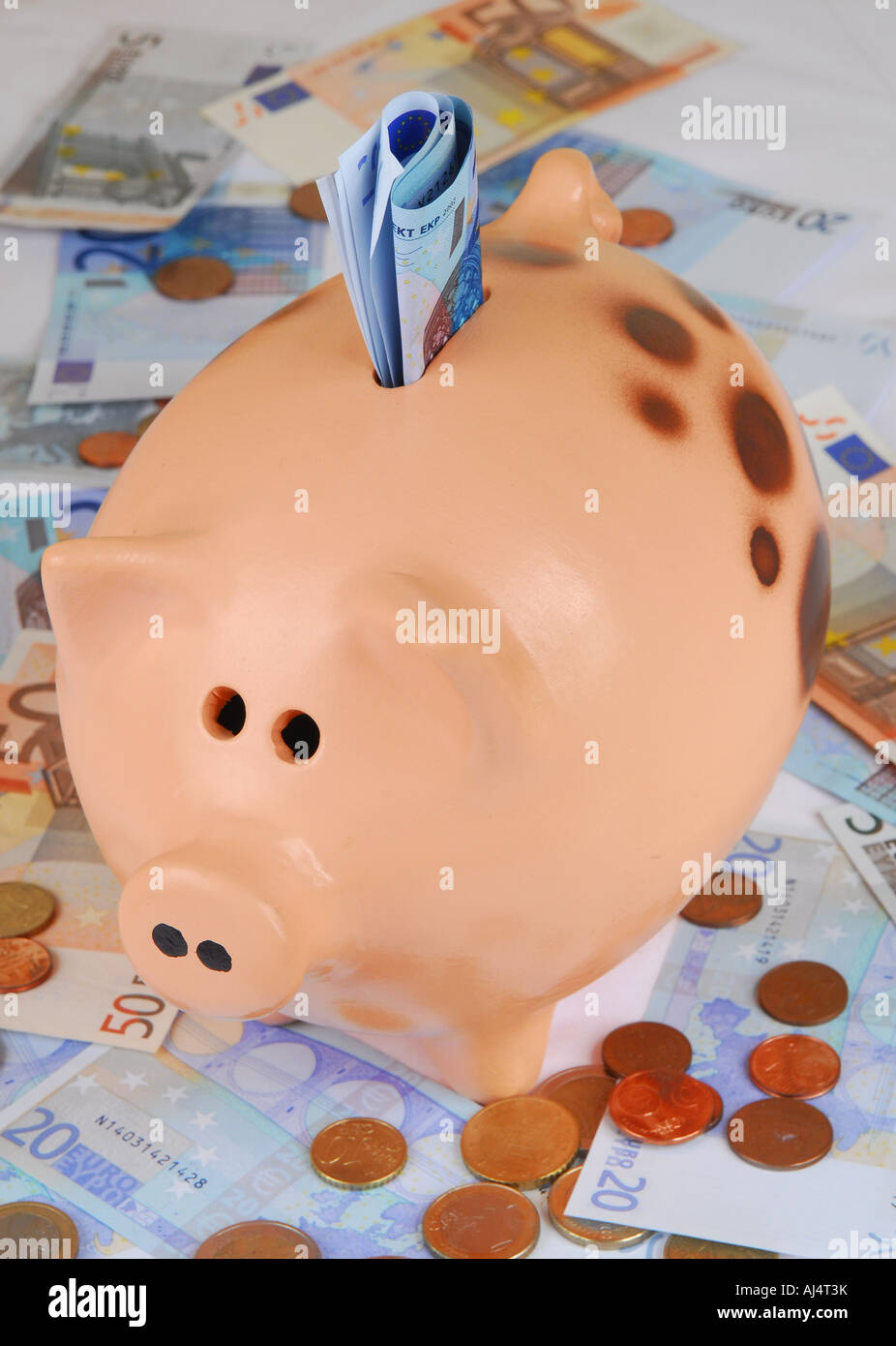 Un gran, fat hucha de pie sobre los billetes y monedas de euro Fotografía  de stock - Alamy
