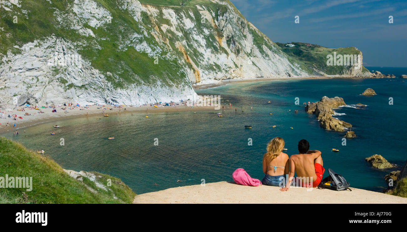 Reino Unido Inglaterra Dorset St Oswald's Bay pareja sentada en el borde del acantilado Foto de stock