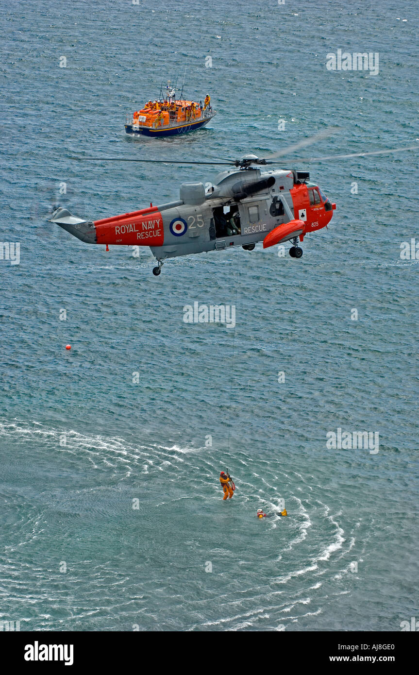 Helicóptero de RNAS Culrose salvavidas RNLI y el lagarto de equipo para una demostración de rescate en Polpeor Cove en Cornwall. Foto de stock