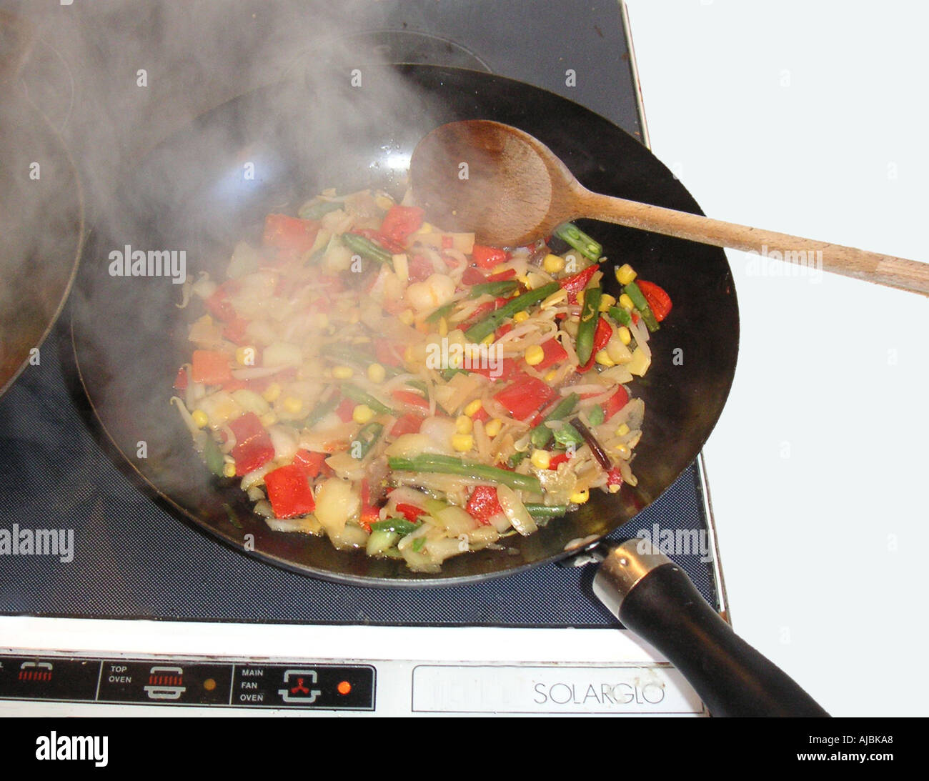 Un salteados en un wok compuesto de castañas de agua cebolla pimientos rojos pimientos verdes judías verdes y el maíz dulce Foto de stock