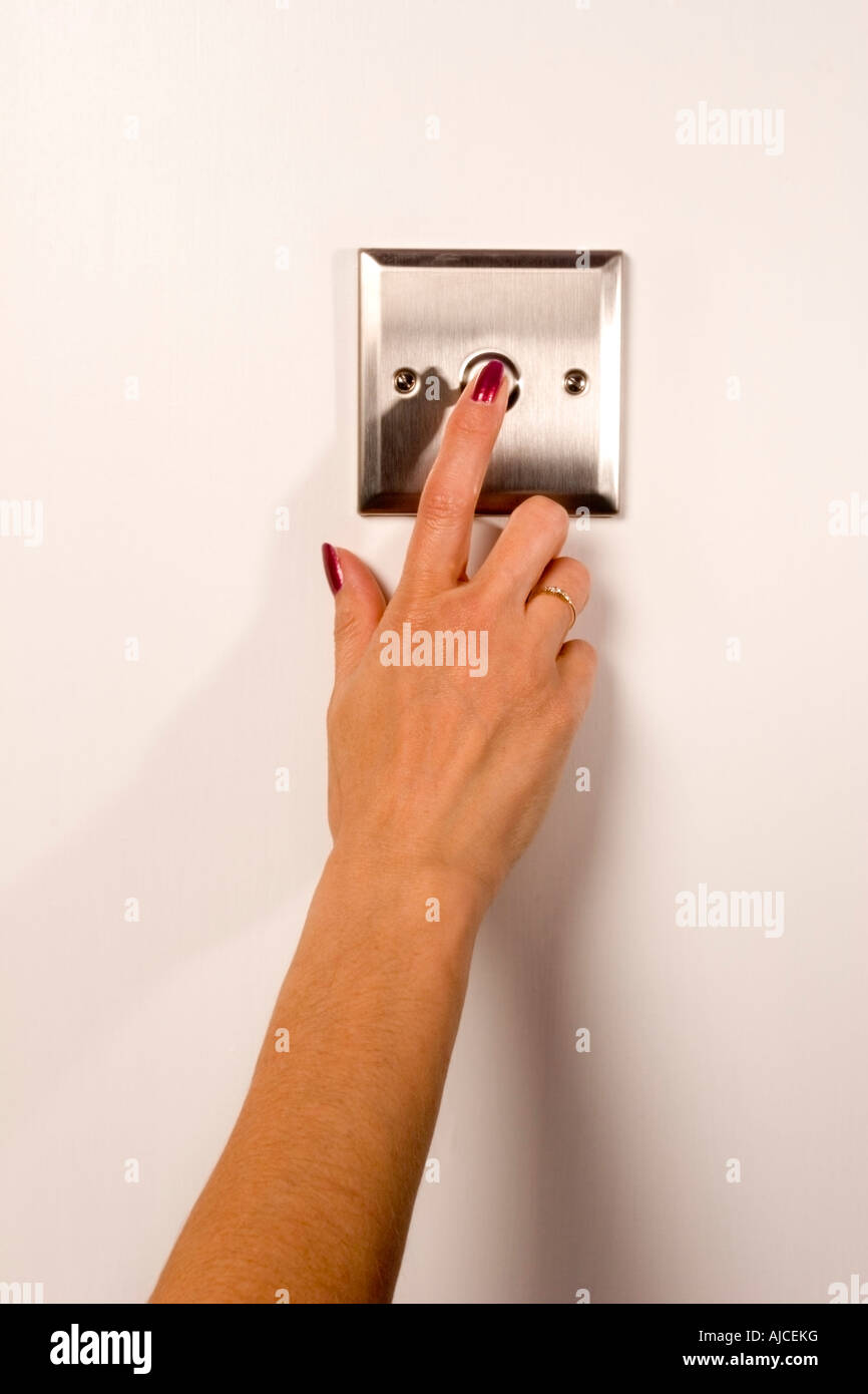 Mujer de primer plano enciende el interruptor en el interruptor de luz de  casa de pared