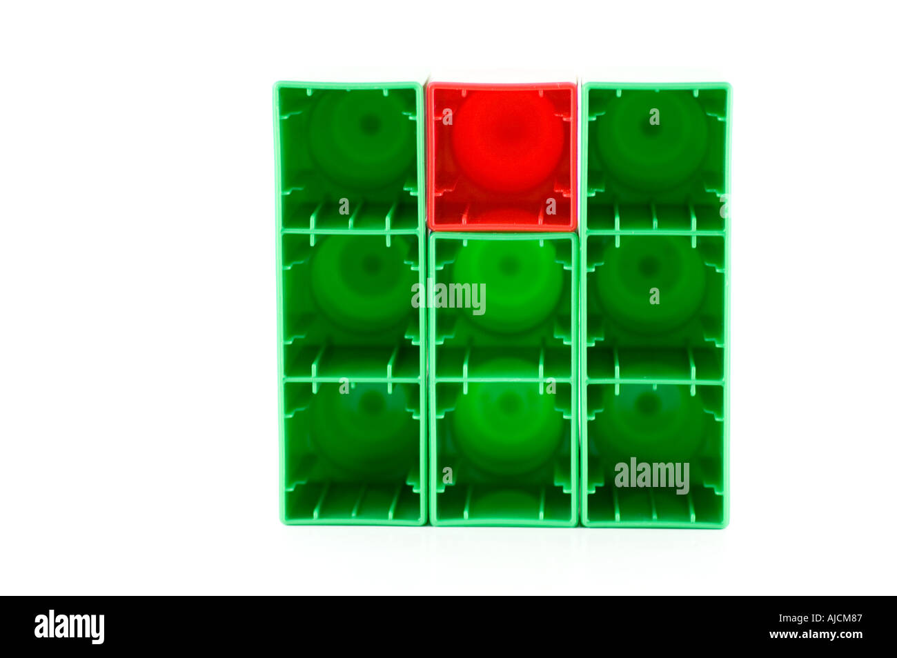 Uno impar un cuadrado de plástico rojo entre los cuadrados verdes Foto de stock
