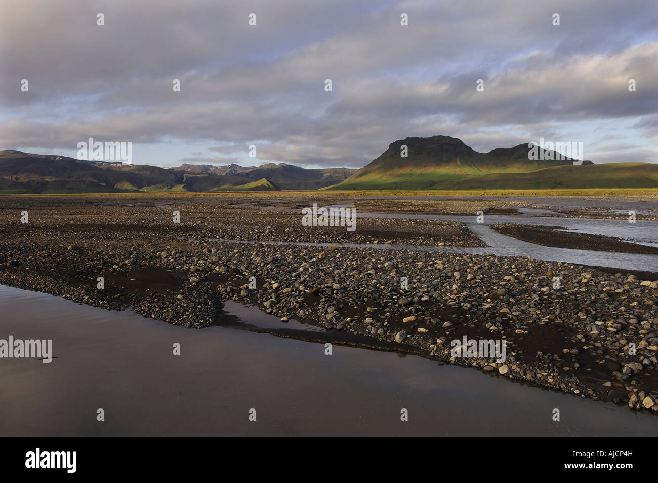 Luz del atardecer sobre las trenzas del río Syslalaekur con tonos de luz sobre las colinas distantes sur de Islandia Foto de stock