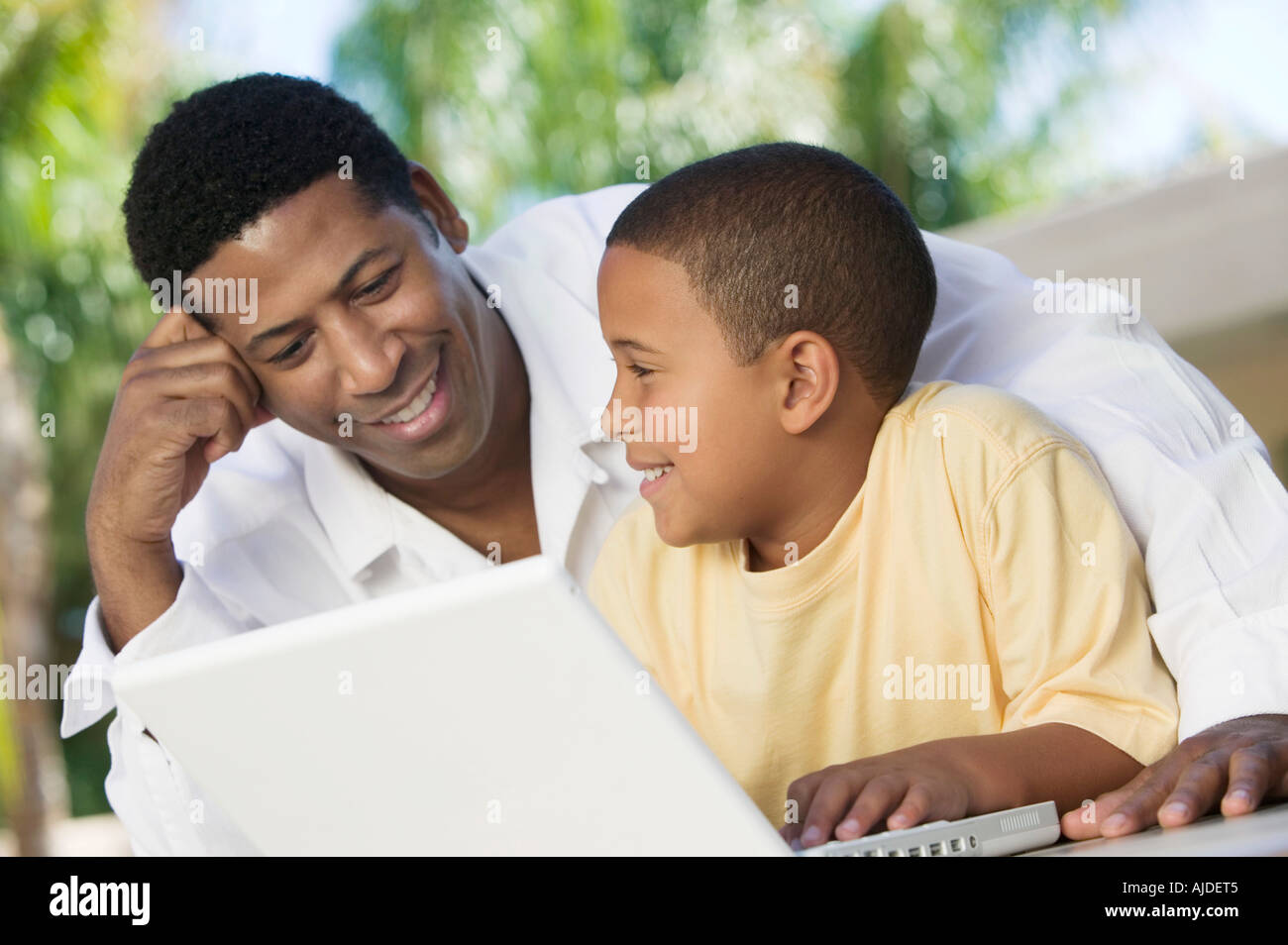 Padre e hijo sentado en el patio con laptop, cerrar Foto de stock
