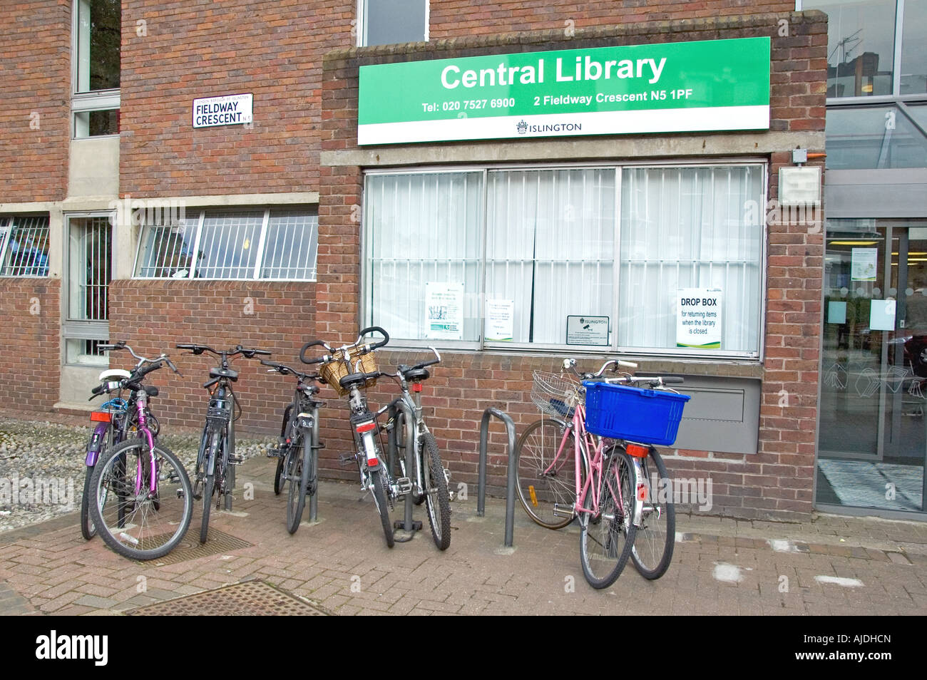 Bicicletas encadenadas a estanterías fuera Islington Biblioteca Central Londres England Reino Unido Foto de stock