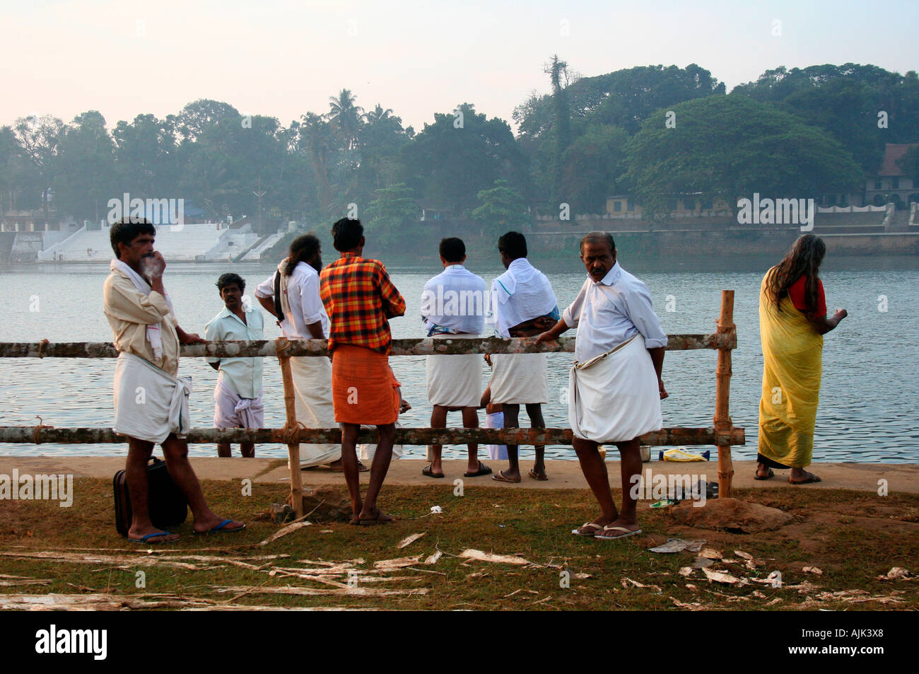 La gente de pie ante el ghat de baño cerca de un templo en Aluva, Kerala Foto de stock