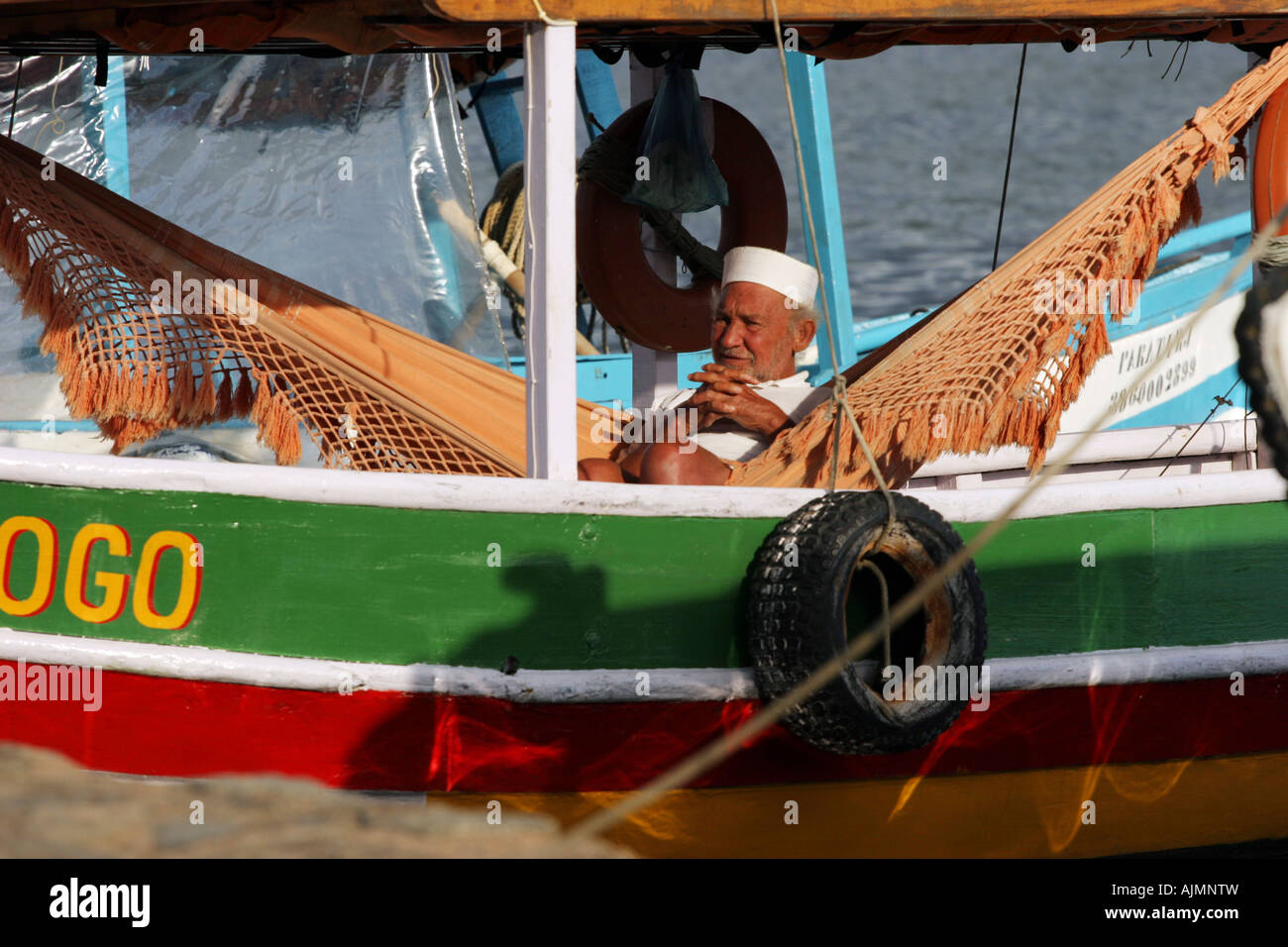 Viejo marinero sentado en una hamaca en su barco turístico esperando para  llevarlos a una excursión a la isla alrededor de varios Paraty Fotografía  de stock - Alamy