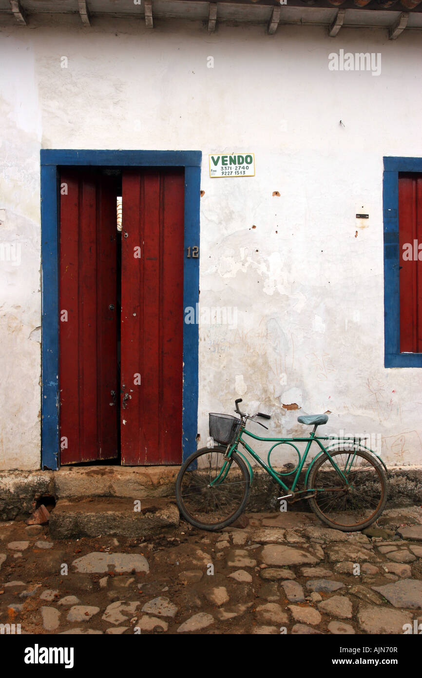 Fachada de una casa humilde en Paraty, Brasil. Una vieja bicicleta está  estacionado en frente de la puerta Fotografía de stock - Alamy
