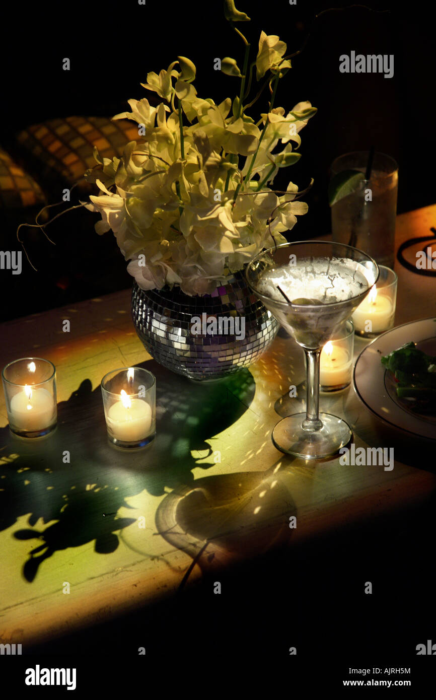Coctel Martini, con olivos en night club. Velas, dramáticas sombras y un jarrón reflejado con orquídeas. Buena zona de copia Foto de stock
