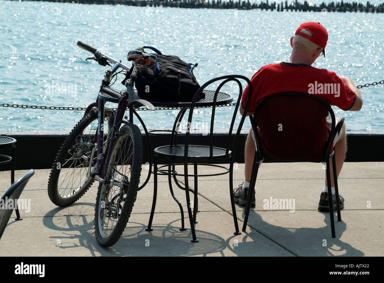 El ciclista se toma un descanso sentado en el Lago Michigan en Navy Pier de Chicago, Illinois, EE.UU. Foto de stock