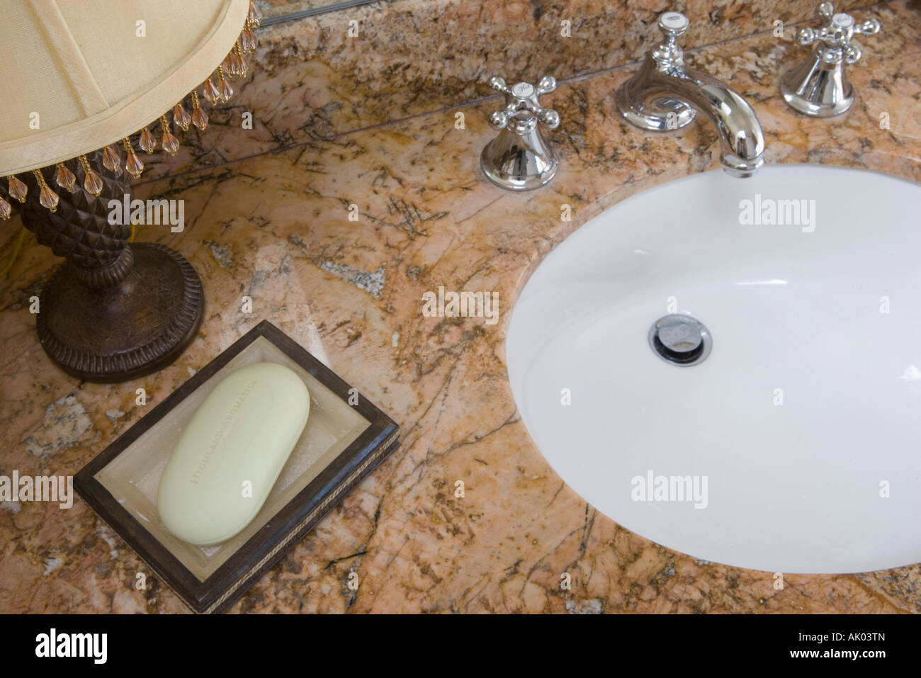 Detalle de lavabo con grifo cromado y jabonera Foto de stock