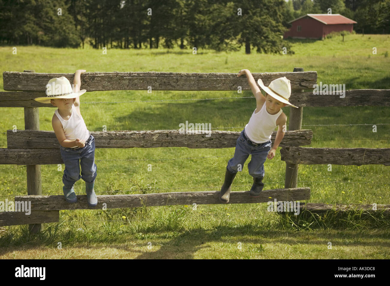 Gemelos en sombreros vaqueros colgados en una valla Fotografía de stock -  Alamy