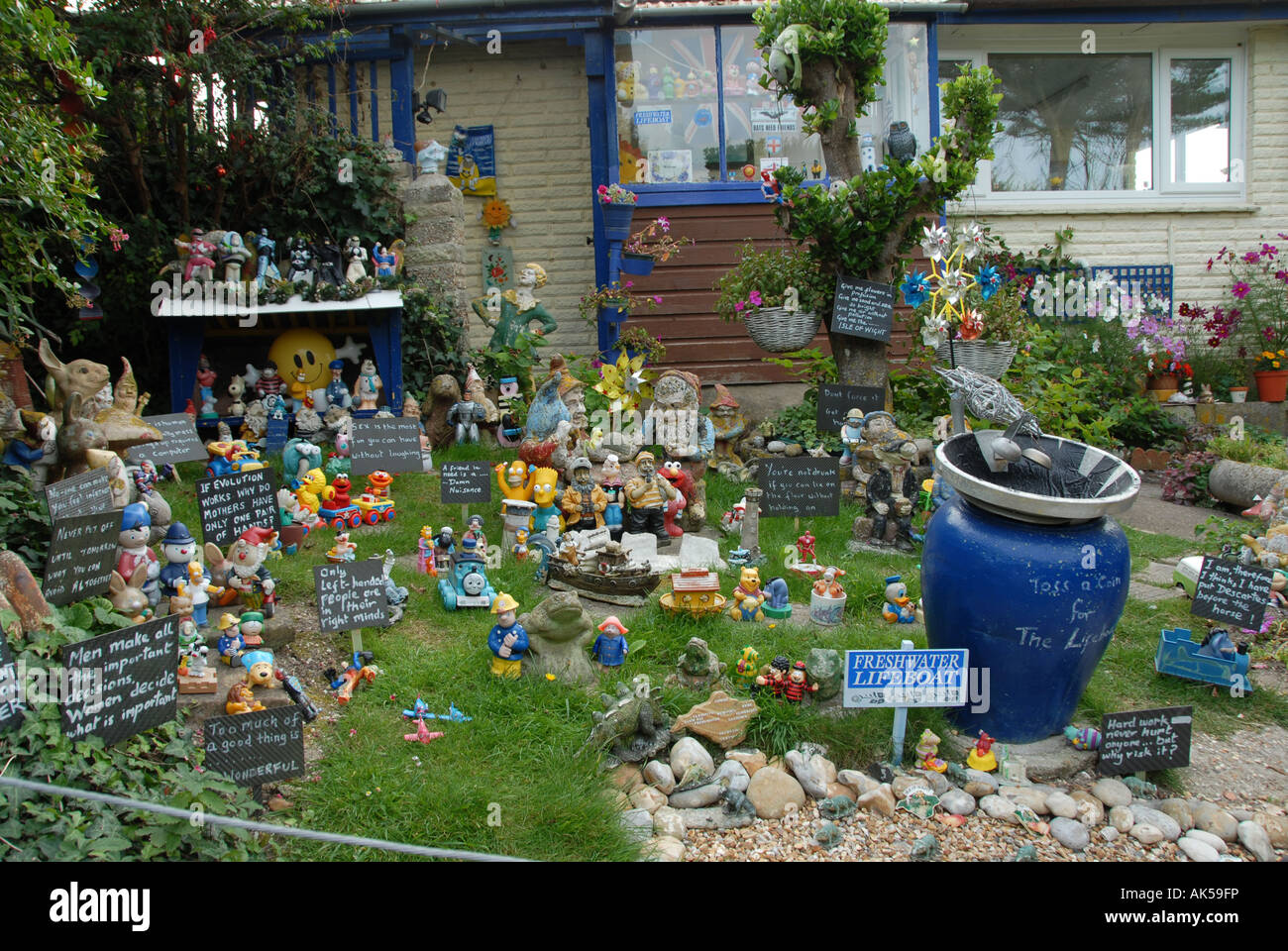 Un jardín de enanos de jardín con una gran colección azul cuenco para el  dinero recaudado para el fondo local de salvavidas, en la Isla de Wight  Fotografía de stock - Alamy