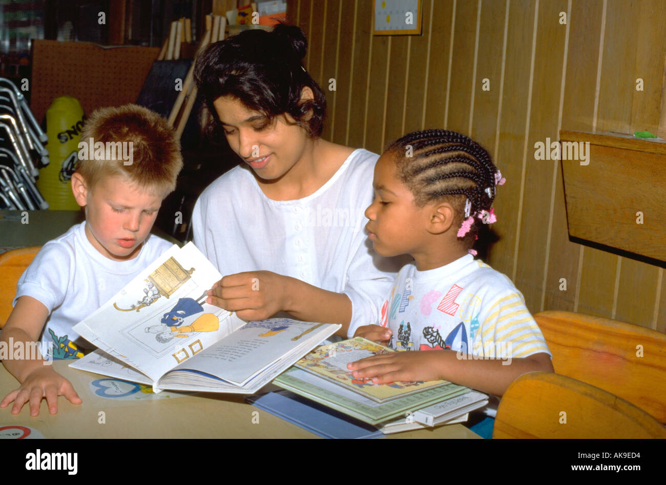 India Oriental chica de 19 años de edad libro de lectura con dos niños de menos de 5 años de edad. St Paul Minnesota, EE.UU. Foto de stock