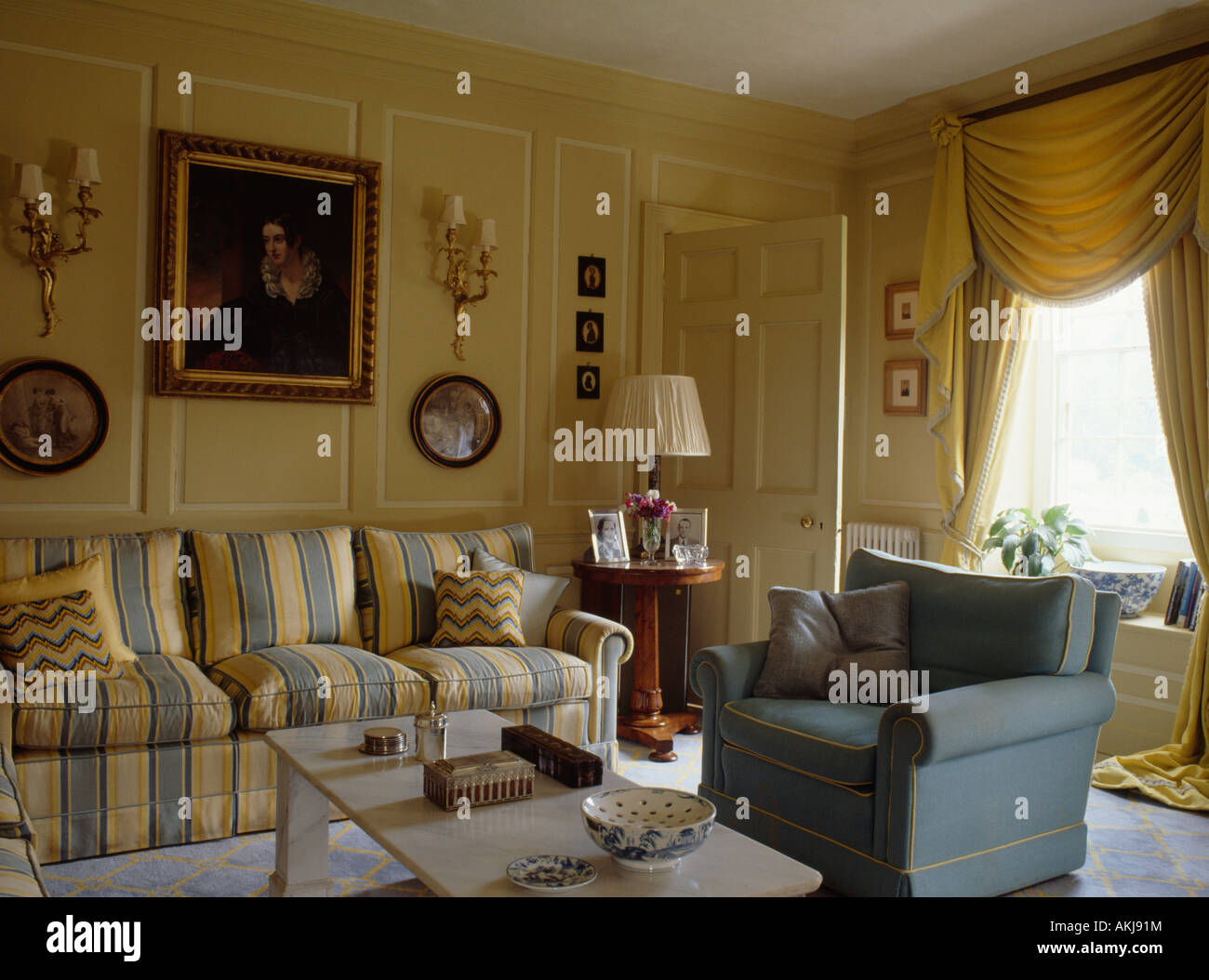 Amarillo y Azul rayados sofá y sillón azul en el salón con paneles de