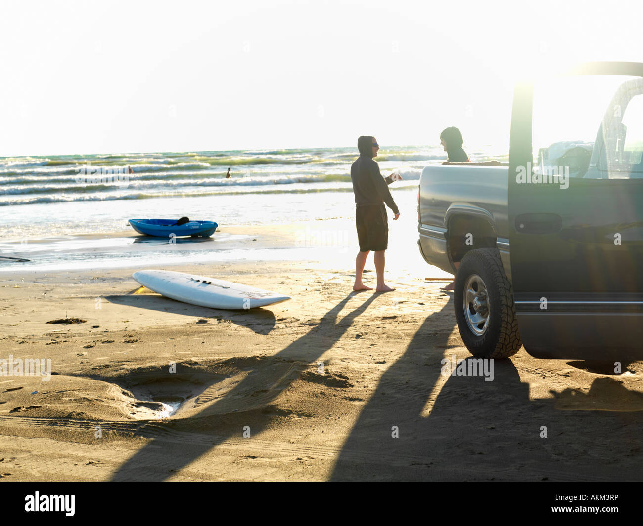 Canadá Ontario Sauble Beach dos amigos varones veinte en la playa con el camión estacionado en la playa con tabla de surf y kayak. Foto de stock