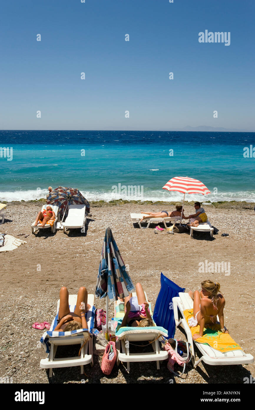 Las personas tomando sol en las reposeras en la playa principal de la  ciudad de Rodas Rodas Fotografía de stock - Alamy