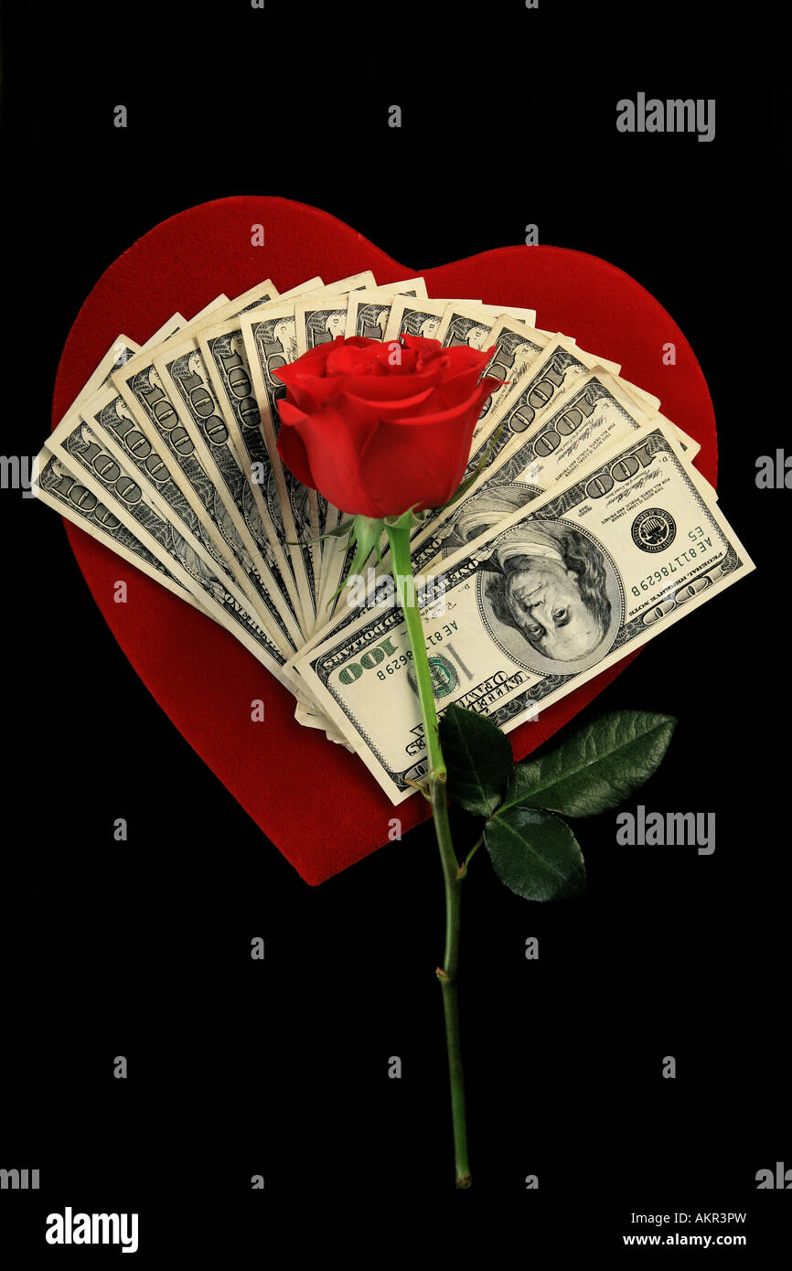 Billetes de cien dólares en terciopelo rojo rosa roja con corazón de San  Valentín aislados en negro Fotografía de stock - Alamy