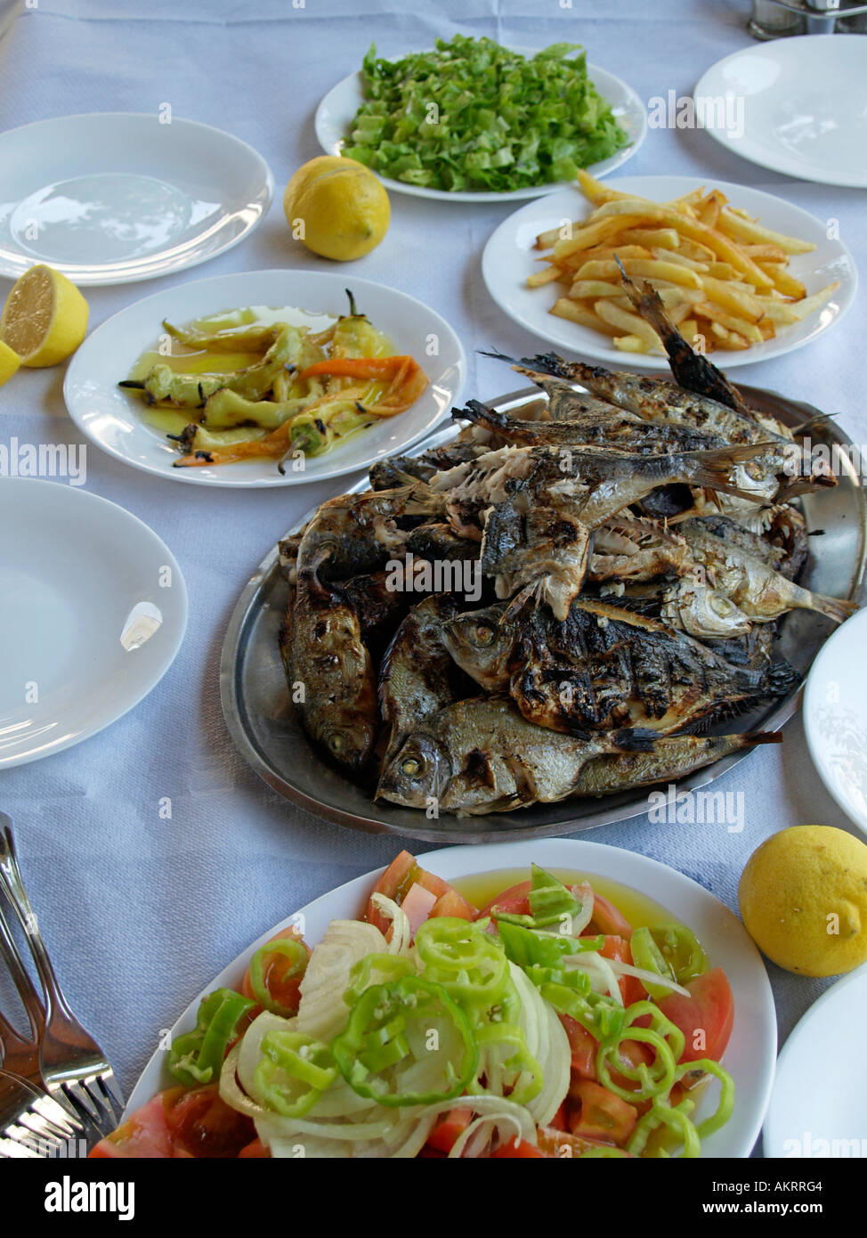 Típica comida Griega con pescado a la parrilla y ensaladas de verduras Foto de stock