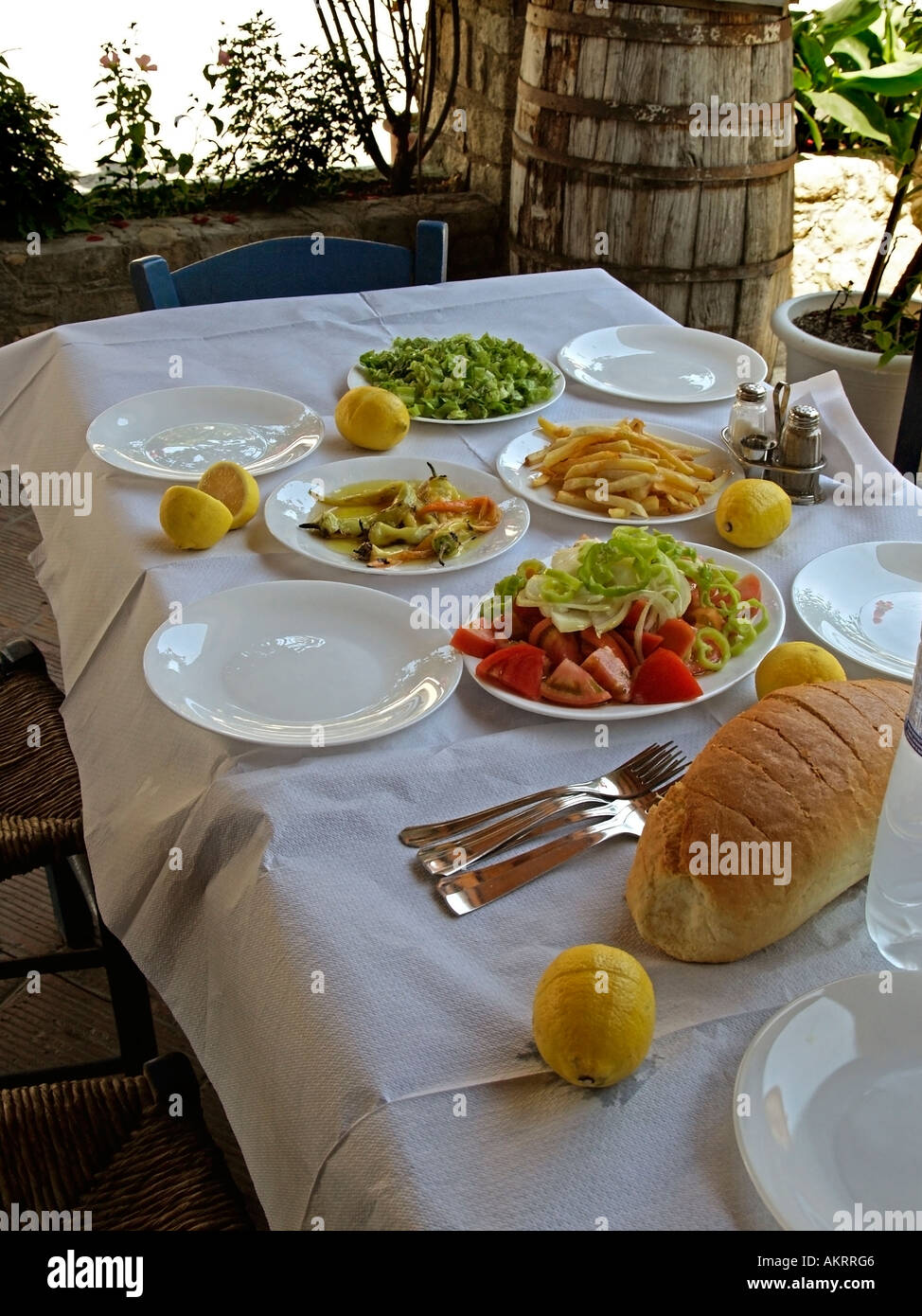 Tabla con lugar y típica comida Griega con pan y ensaladas de verduras Foto de stock