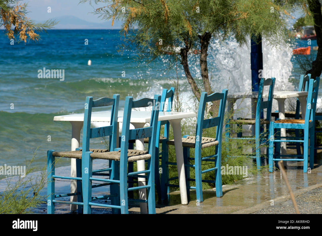 Mesas y sillas de un bar restaurante Kafenion griego cerca del mar, en la costa de la península de Horto Pilion Tesalia Foto de stock