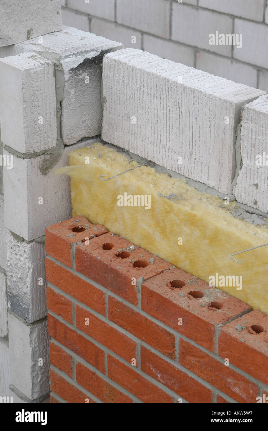 Parte de una nueva casa en construcción que muestra las capas de Breeze  block, aislamiento y ladrillos Fotografía de stock - Alamy