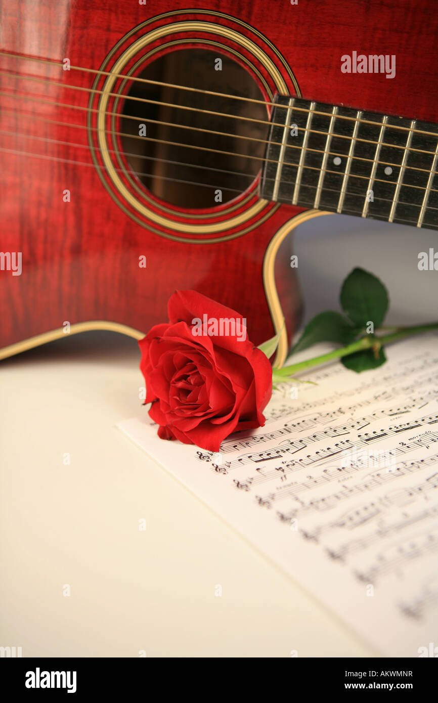 Guitarra acústica con rojo rosa roja y partituras Fotografía de stock -  Alamy