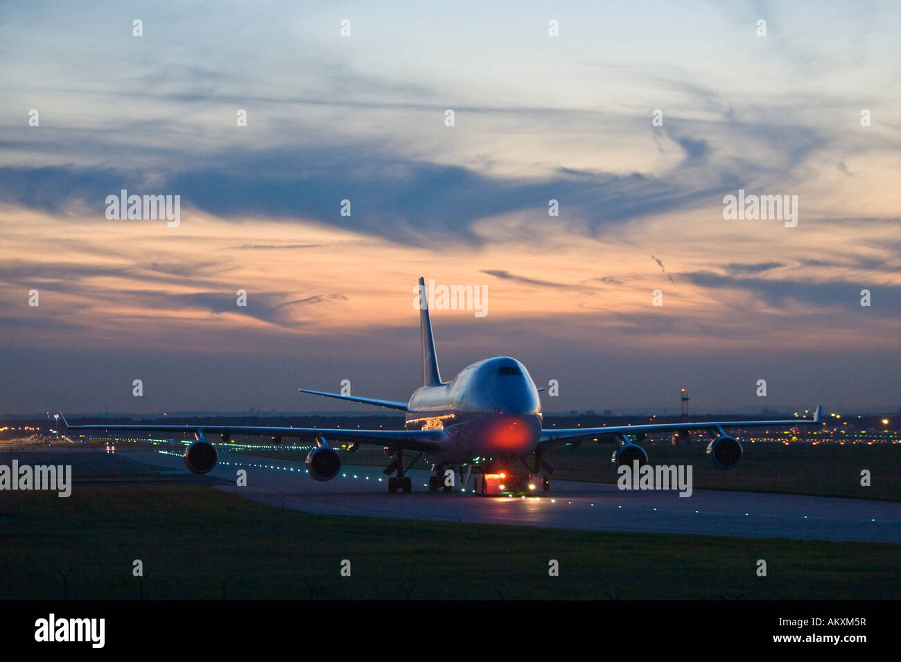 Un Boeing 747 se arrastra en la noche sobre el campo de aterrizaje. Foto de stock