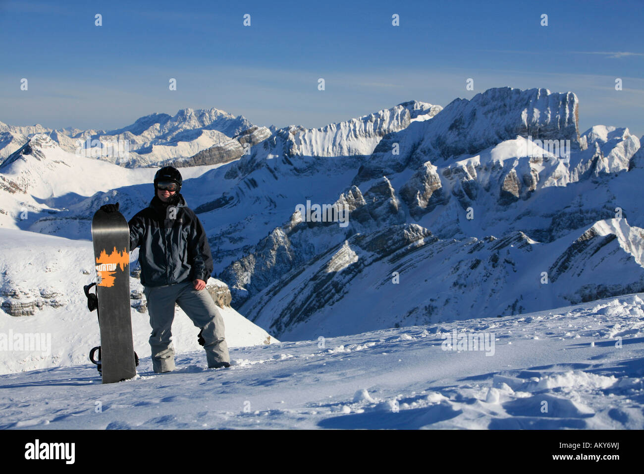 Bien protegido el snowboarder con casco y Burton tablero delante del panorama de los Alpes, Toggenburg, San Gall, Suiza Foto de stock