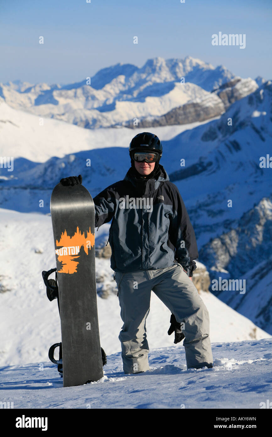 Bien protegido el snowboarder con casco y Burton tablero delante del panorama de los Alpes, Toggenburg, San Gall, Suiza Foto de stock