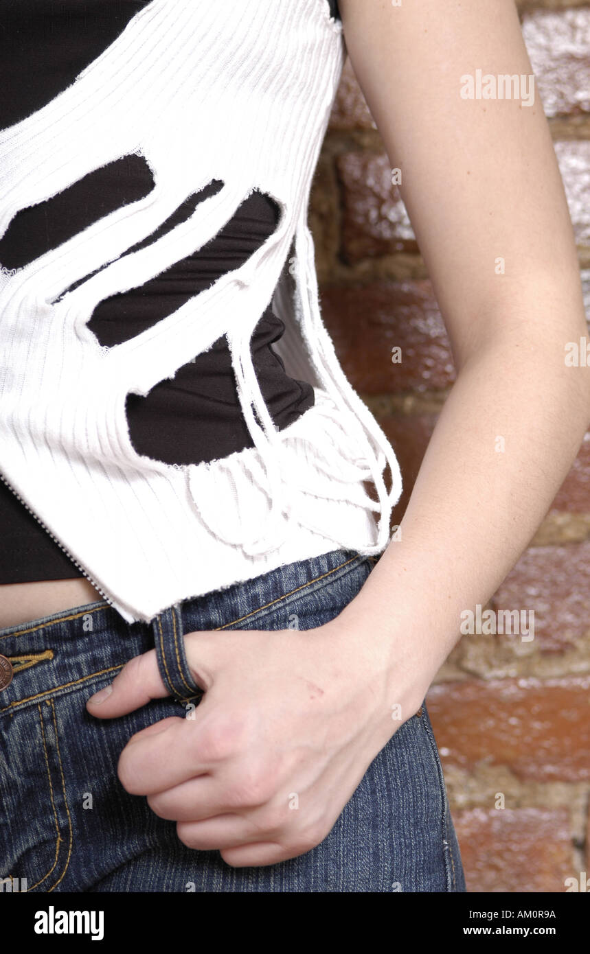 Mujer chica pantalones vaqueros cinturón casual de plástico PVC torn rip cortar manos del brazo hembra caucásica Fotografía de stock - Alamy