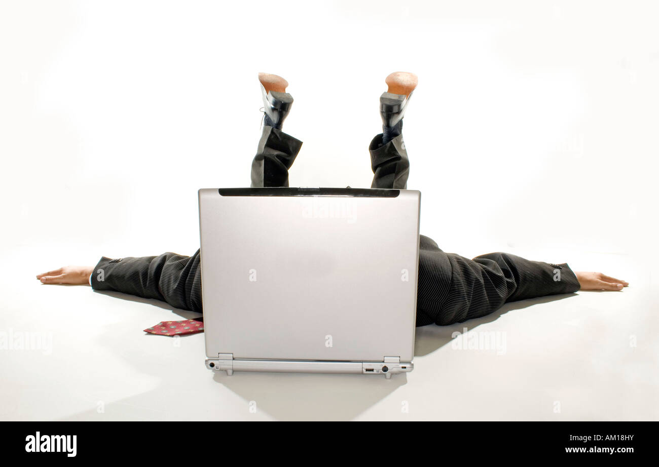Hombre de negocios acostado con extiende los brazos detrás de un portátil Foto de stock