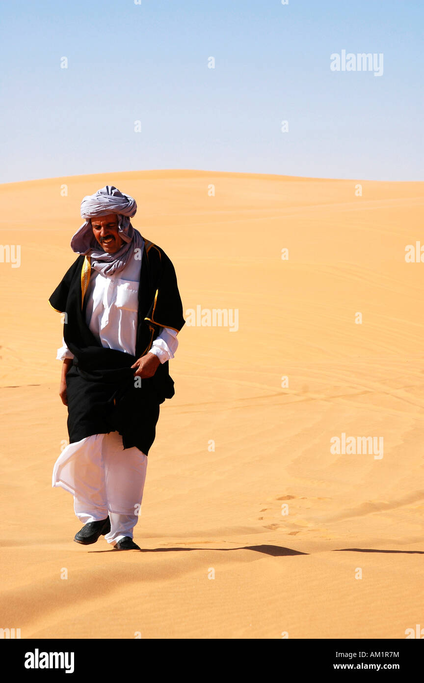 Hombre árabe regresa de la oración en el desierto del Sahara, Libia Foto de stock